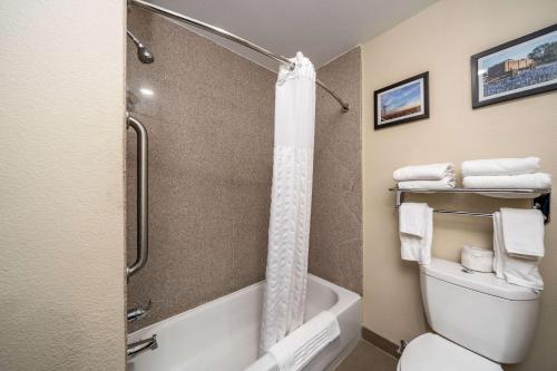 阿比林阿比林大学康福特套房酒店的浴室配有淋浴和带毛巾的卫生间。