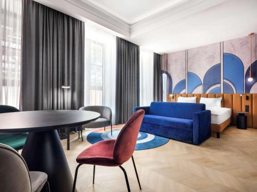 克拉科夫Mercure Krakow Fabryczna City的酒店客房配有蓝色的沙发和桌子