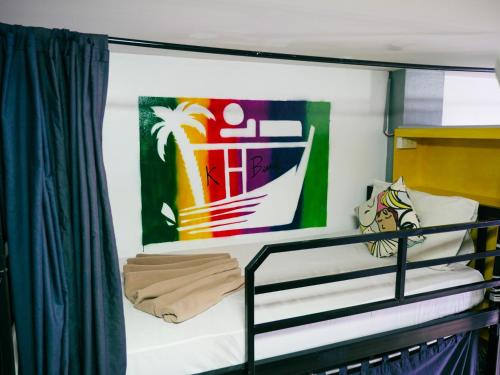 奥南海滩K-Bunk Hostel的船上的一张双层床,墙上挂着一幅画