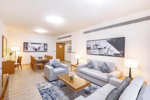 迪拜Golden Sands Suites的客厅配有沙发和桌子