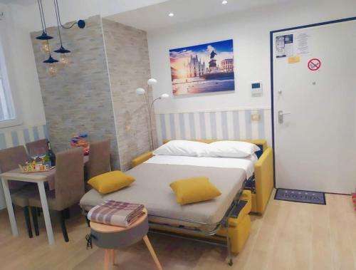 米兰San Siro Dream Home -Apartment with garage-Milano的一间卧室配有一张带黄色枕头和桌子的床