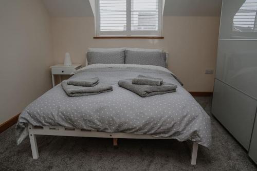 特罗布里奇Lovely new 1 bedroom loft apartment with on drive parking的卧室内的一张带枕头的床