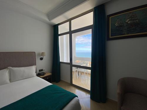 卡萨布兰卡蓝色海岸酒店 的一间卧室设有一张床和一个大窗户