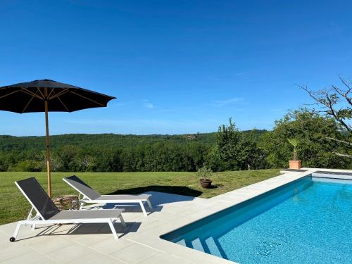 圣西普里安Domaine de Cazal - Gîte 4 pers avec piscine au cœur de 26 hectares de nature préservée的一个带两把椅子和遮阳伞的游泳池