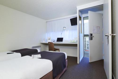 里尔里尔南基钟楼酒店 - CHR的酒店客房配有两张床和一张带笔记本电脑的书桌
