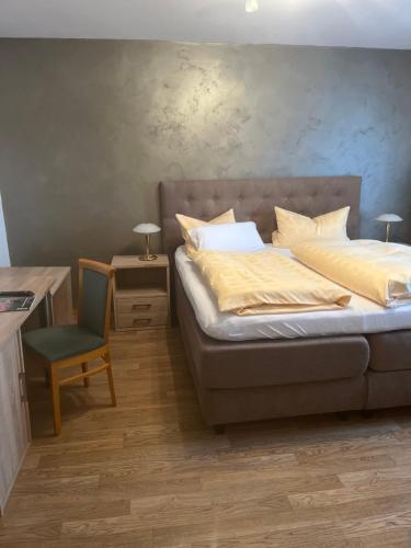 BremenGasthof Wulf的卧室配有1张床、1张桌子和1把椅子