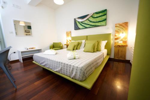 萨莱诺B&B Milleduecento Luxury Room的一间卧室配有一张带绿色床头板的床