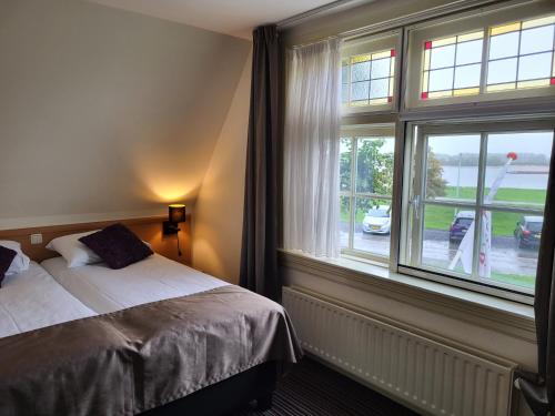 Rossum德盖尔登莫伦酒店的一间卧室设有一张床和一个大窗户