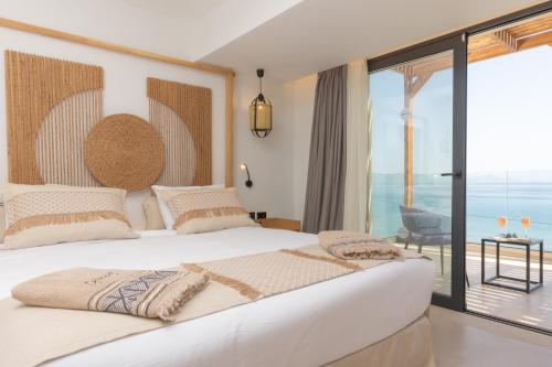 卡尔扎迈纳Cabana Blu Hotel & Suites的一间卧室设有一张大床,享有海景