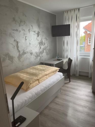 BremenGasthof Wulf的一间卧室配有一张床、一张书桌和一个窗户。
