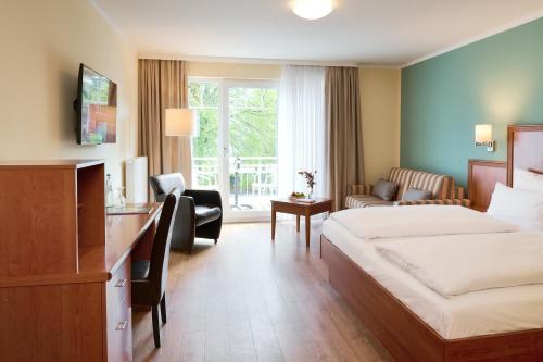 巴贝R&R Strandhotel Baabe的配有一张床和一张书桌的酒店客房