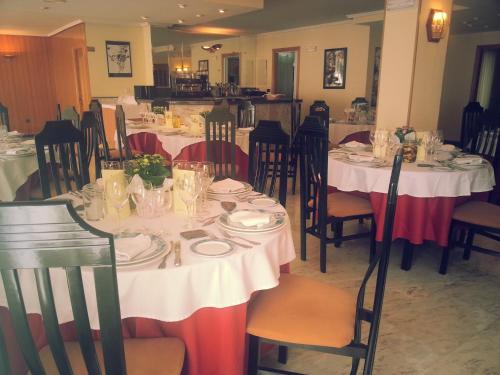 比利亚夫利诺拉布拉尼娜酒店的用餐室配有桌椅和白色桌子