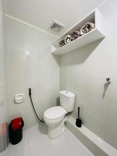 伊洛伊洛Lovely 2 bedroom condo unit的白色的浴室设有卫生间和架子。