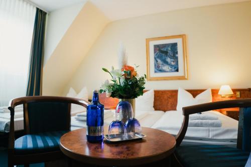 杜塞尔多夫老城圣乔治酒店的一间酒店客房,配有一张桌子和两瓶