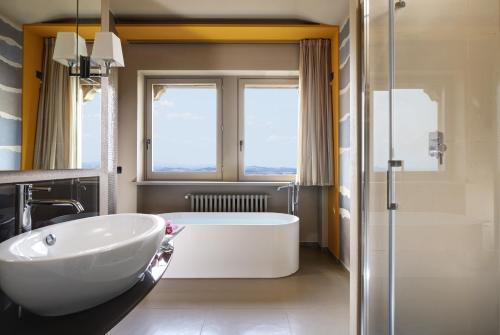 圣马力诺蒂塔诺套房酒店的一间带大型白色浴缸和淋浴的浴室