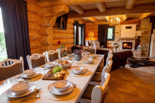 IzvoareHarghita Log Houses的一间带长桌和椅子的用餐室
