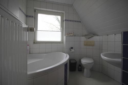 多尔努姆Ferienhaus Brigitte的带浴缸、盥洗盆和卫生间的浴室