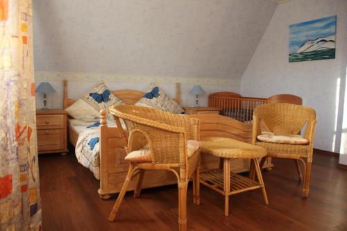 多尔努姆Ferienhaus Brigitte的一间卧室配有带藤椅和桌子的床