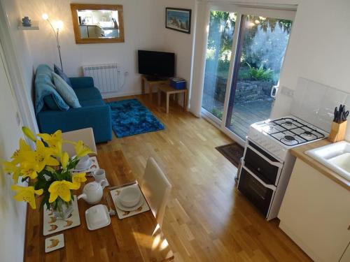 Saint DominickOakey Orchard - cosy apartment in Tamar Valley, Cornwall的客厅设有蓝色的沙发和黄色的花桌