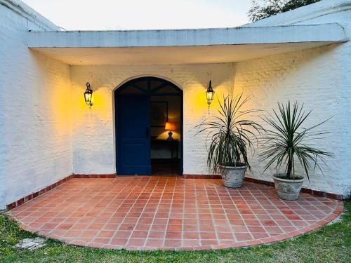 埃斯基纳La Mansa Riverside的两棵盆栽植物的房子的前门