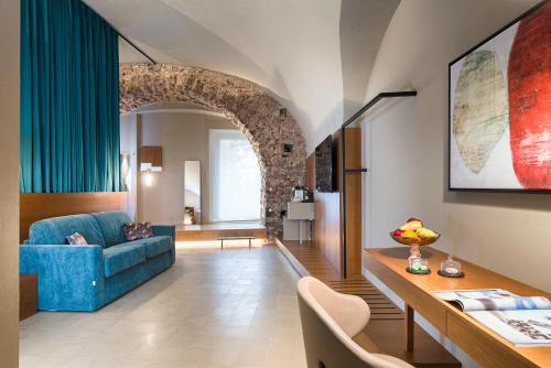 卡塔尼亚BASTIÒ PRIVATE SUITES的客厅设有蓝色的沙发和拱门
