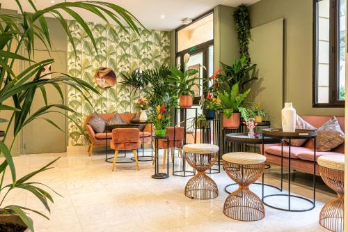 巴黎帕特里克哈亚特阿丽亚娜蒙帕纳斯酒店的客厅配有桌椅和植物
