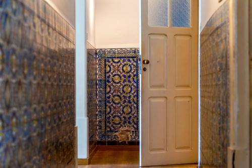 科英布拉AltoCanto的一条带白色门和瓷砖墙的走廊