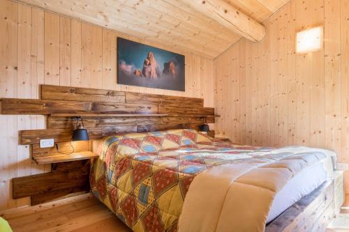 圣马蒂诺-迪卡斯特罗扎Baita Dani的卧室配有一张床铺,位于带木墙的房间内