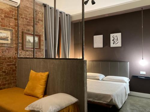 米兰卡吕普索酒店的一间卧室设有两张床和砖墙