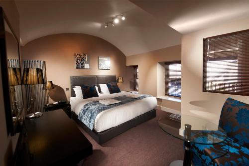 圣彼得港公爵酒店的一间卧室配有一张床、一张桌子和一把椅子