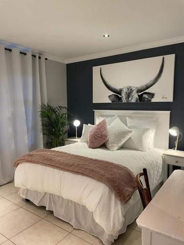 普利登堡湾Lux apartment Plett的一间卧室,卧室里配有一张带公牛照片的床