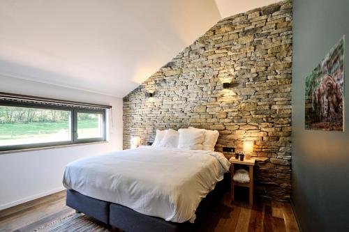 BraLe Domaine de Bra的一间卧室设有石墙和一张床