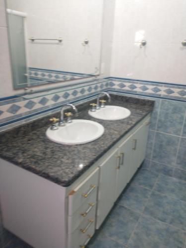 塞拉内格拉Casarão Primavera的一间带两个盥洗盆和大镜子的浴室