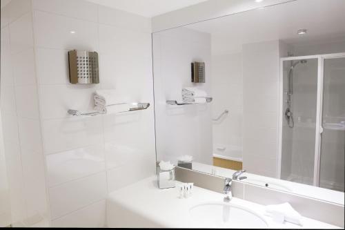 克劳道金路易菲茨杰拉德酒店的白色的浴室设有水槽和淋浴。