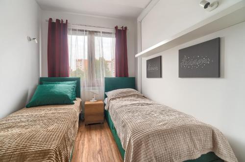 什切青Apartament Milion Rynek Sienny Stare miasto Apartamenty No.1的一间卧室设有两张床和窗户。