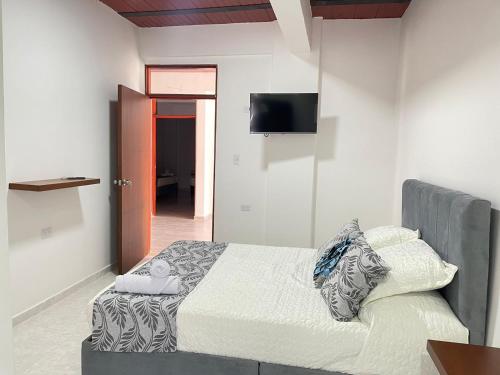比利亚维哈Casa Hotel Estelar的一间卧室配有一张床和一台平面电视