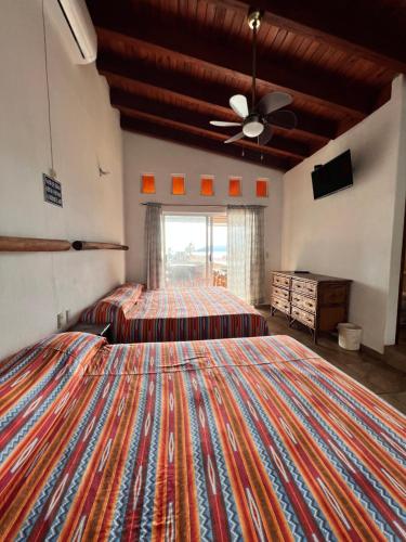 锡瓦塔塔内霍Villa el Arca的一间带两张床和吊扇的大卧室