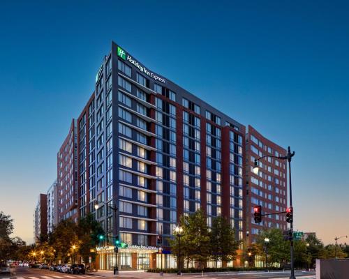 华盛顿Holiday Inn Express - Washington DC Downtown, an IHG Hotel的夜幕降临的城市街道上一座高楼