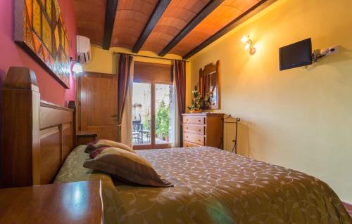 Valdealgorfa萨尔瓦多科拉尔瓦莱罗乡村别墅的一间卧室配有一张床、一个梳妆台和一扇窗户。