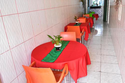 圣路易斯Pousada Aconchego的一排桌子,有红色和橙色的椅子