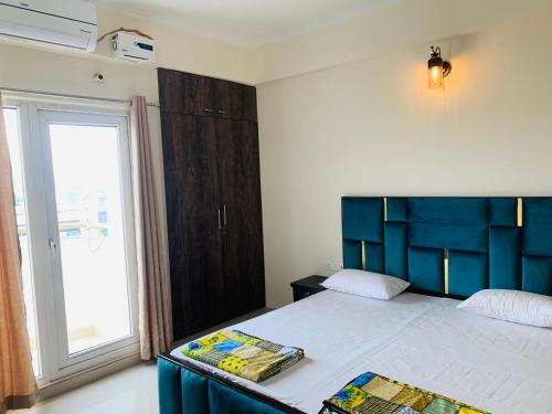 瓦拉纳西Tranquil (Near Ghats and Temple)的一间卧室配有一张带蓝色床头板的床和窗户