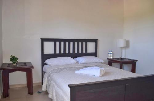 Puerto de LuperonPuerto Blanco Marina & Hotel的一间卧室配有一张大床和两张床头柜