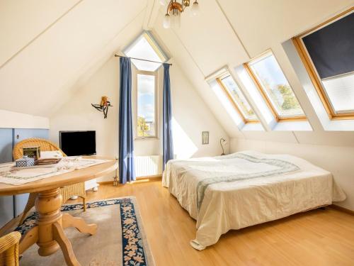 霍恩Comfy holiday home in Hoorn with garden的卧室配有一张床、一张书桌和窗户。