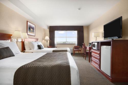 兰利戴斯套房兰利酒店的酒店客房设有两张床和一台平面电视。