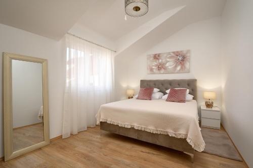 卡什泰拉Zora Residence的白色卧室设有一张大床和镜子