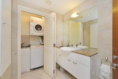 道格拉斯港鸡蛋花别墅的白色的浴室设有水槽和镜子