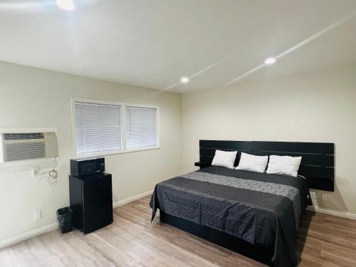 英格尔伍德Holly Park Motel near LAX的一间卧室设有一张大床和两个窗户。