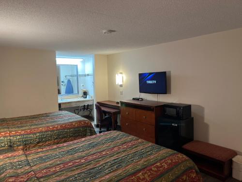 AmoryBriarwood Inn的酒店客房设有两张床和一张书桌及电视