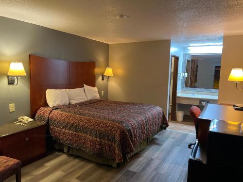 AmoryBriarwood Inn的配有一张床和一张书桌的酒店客房