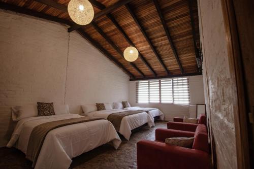 巴尼奥斯Rústic Quinta La Aurora的带四张床和窗户的客房
